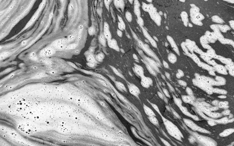 photo mise en avant - j’écume j’m’enrhume - janvier 2025. représente les marque de l'écumes sur l'eau de mer, photos en noir et blanc